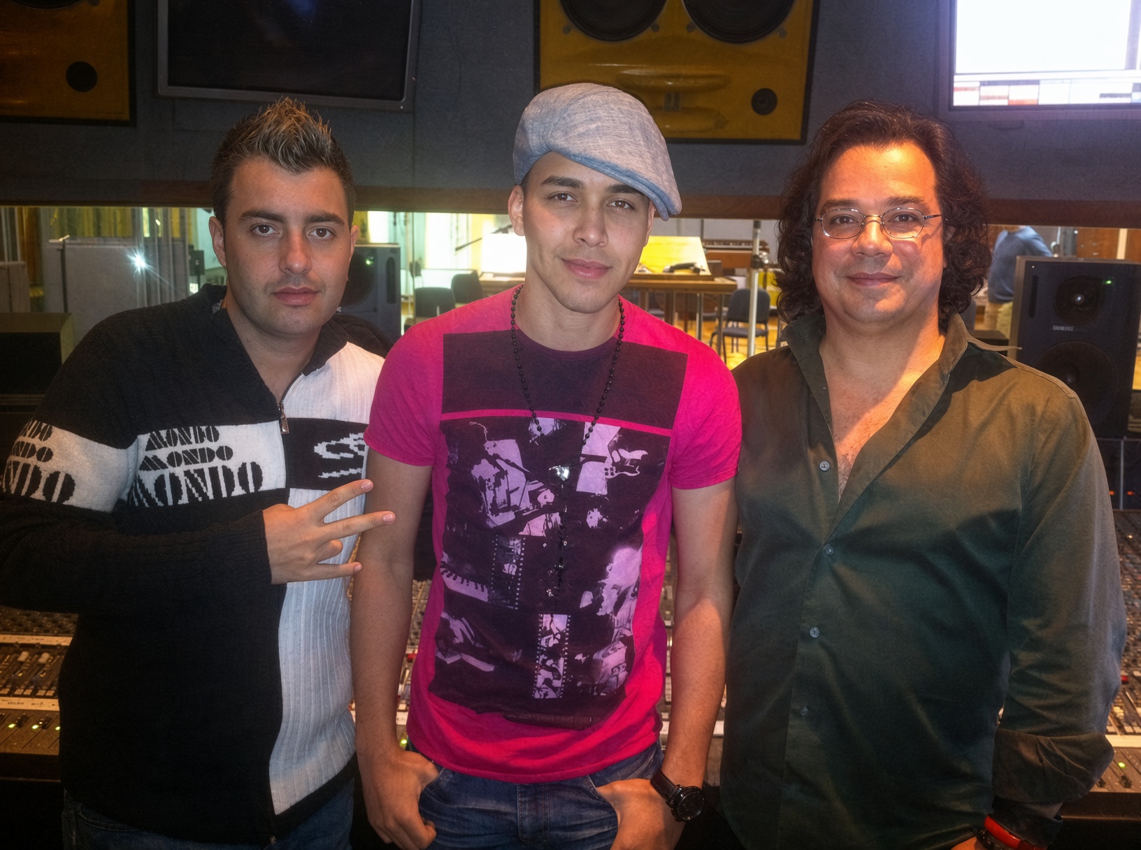 Three collaborators standing together in a recording studio